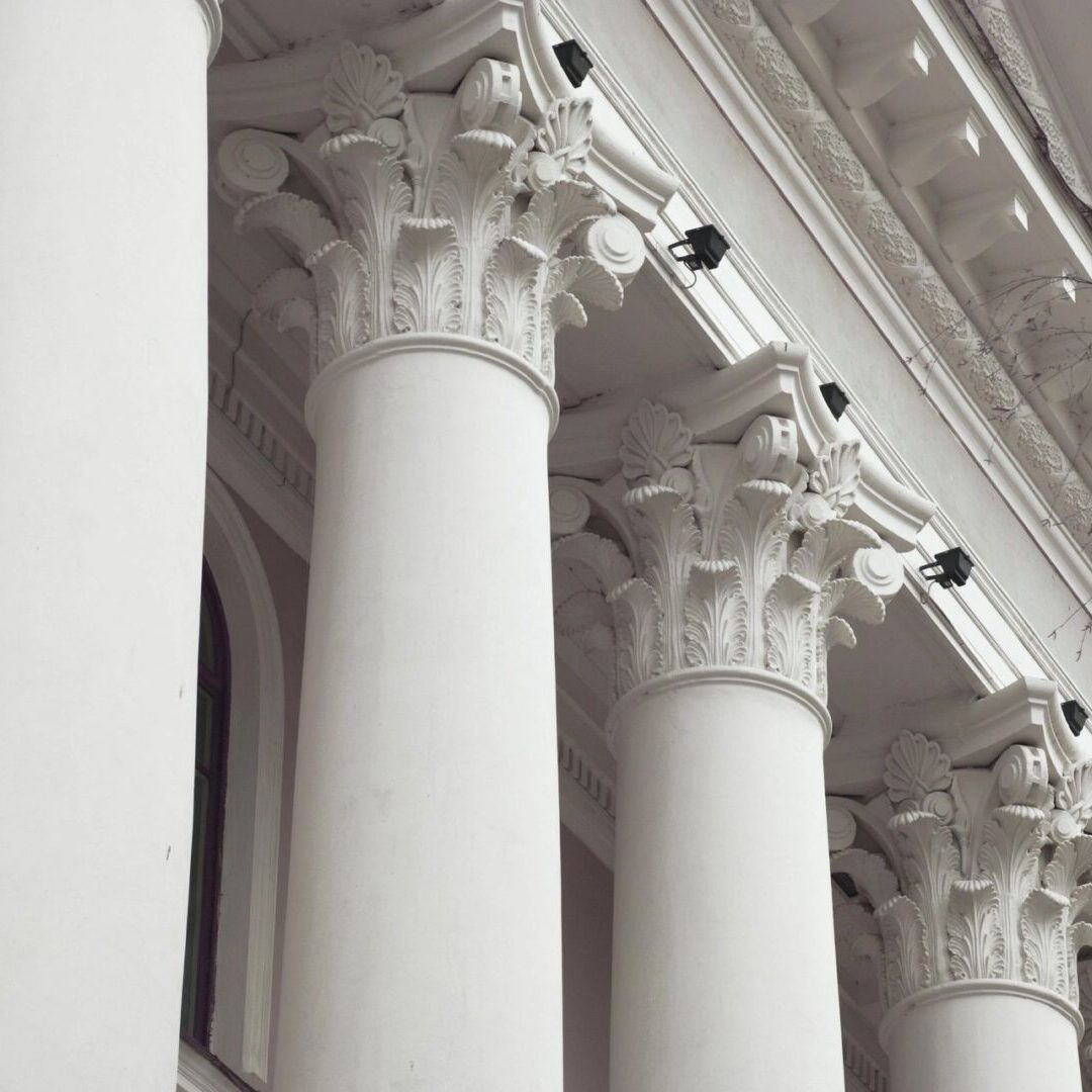 A white building with pillars and security cameras.