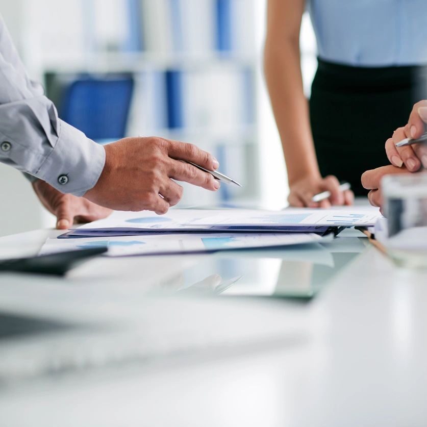 A group of people sitting at a table with papers.